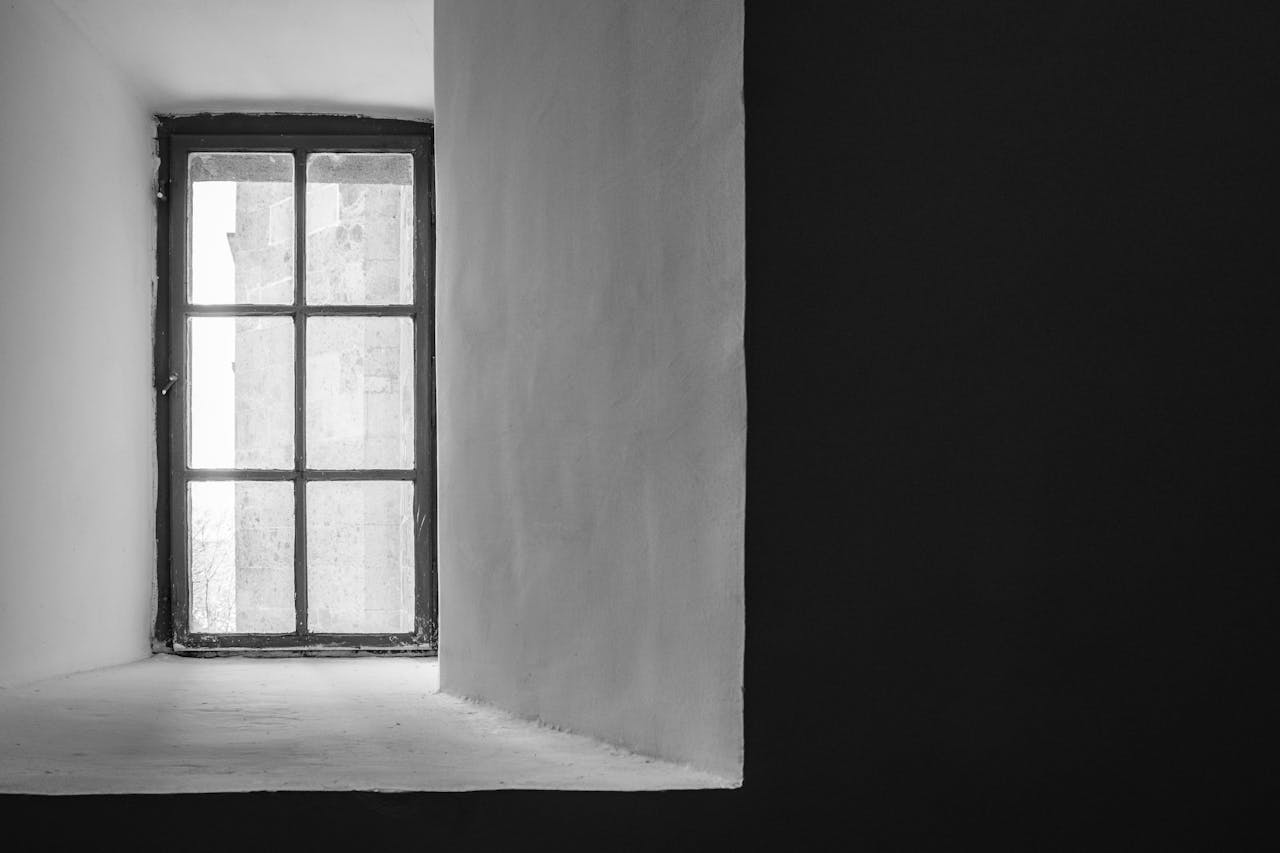 services-01 A minimalist black and white photograph of a window with a view outside.